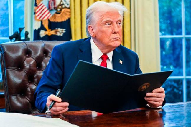 US President Donald Trump signs the document appointing Chris Rocheleau new deputy Federal Aviation Administration (FAA) Administrator in the Oval Office of the White House on January 30, 2025 in Washington, DC. Roberto Schmidt / AFPpix