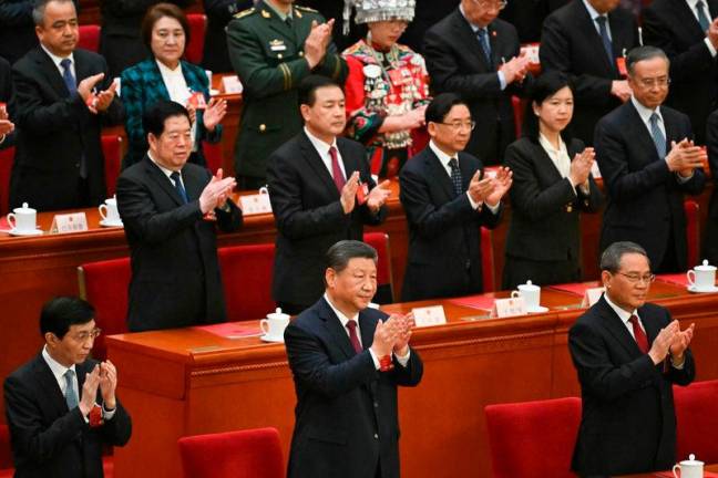 FILEpix: China’s President Xi Jinping and Premier Li Qiang applaud at the end of the closing session of the National People’s Congress (NPC) at the Great Hall of the People in Beijing. AFPpix