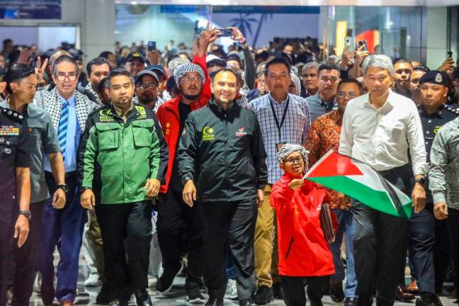 Foreign Affairs Minister Datuk Seri Mohamad Hasan (second right) walking with Sumud Nusantara leaders and supporters during the welcoming ceremony for 23 Malaysian activists who returned from the Global Sumud Flotilla mission at Kuala Lumpur International Airport (KLIA) last night. ADAM AMIR HAMZAH THESUN