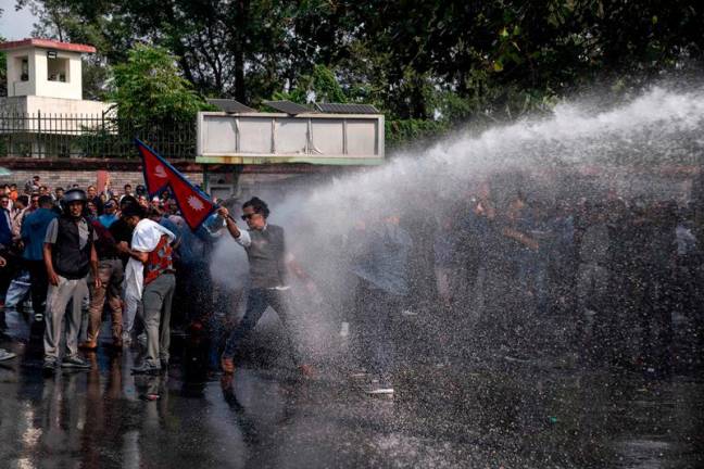 Police use water cannons to disperse supporters of Rabi Lamichhane, Nepal's former deputy premier, protesting after his arrest on fraud and organised crime charges, in Pokhara on October 20, 2024. Nepali police fired water cannons and tear gas on October 20 at thousands of protesters loyal to a former deputy premier once seen as a rising political star, as he appeared in court on charges his supporters say are politically motivated. - Yunish GURUNG / AFP