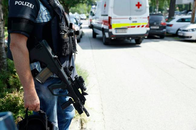 A policeman is seen next to an ambulance car close to a school where, according to reports, several people died in a shooting, on June 10, 2025 in Graz, southeastern Austria. Several people died in a school shooting, including the attacker, Austrian broadcaster ORF quoted the interior ministry as saying. - ERWIN SCHERIAU / APA / AFP