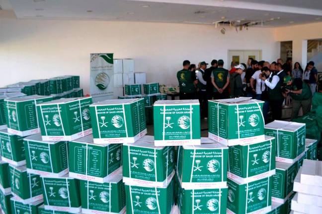 Activists distribute humanitarian aid sent from Saudi Arabia to displaced people from southern Lebanon living in shelters in Tripoli on October 19, 2024. - Fathi AL-MASRI / AFP