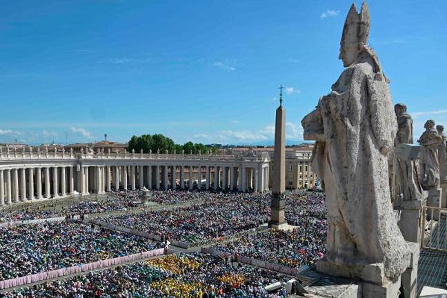 People attend a holy mass a day after the funeral of Pope Francis, at St Peter’s square with the obelisk and the colonnade, in The Vatican, on April 27, 2025. - Damien MEYER / AFP