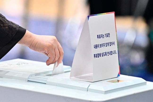 A person casts their vote at a polling station in Seoul during the presidential election on June 3, 2025. Polls opened June 3rd for South Korea’s snap presidential election, with the country voting to choose a new leader after ex-president Yoon Suk Yeol was impeached over his abortive declaration of martial law. - Pedro Pardo / AFP