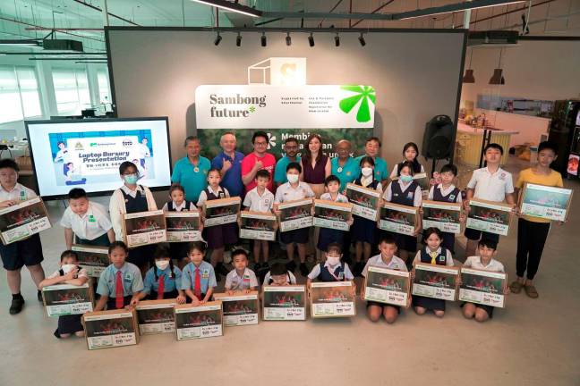 Student beneficiaries proudly showing their newly received refurbished laptops at the launch of the Sports Toto “Laptops 4 Kids” Learning Program 2025