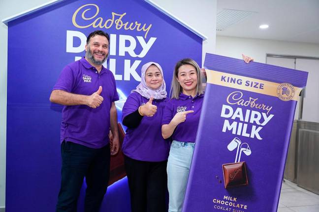 From left: Mondelez International (Malaysia) manufacturing director Abdallah Habib, Mondelez International (Malaysia &amp; Singapore) corporate and government affairs head Raja Zalina Raja Safran and See unveiling the Cadbury King Size 200gm bar in Shah Alam today.