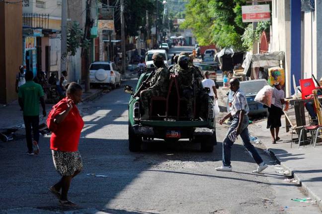 Members of the Haitian Armed Forces patrol the area as people flee homes following the armed gangs violence over the weekend, many grouped behind an alliance known as Viv Ansanm, at the Poste Marchand suburb, in Port-au-Prince, Haiti December 9, 2024. - REUTERS/Ralph Tedy Erol/File Photo