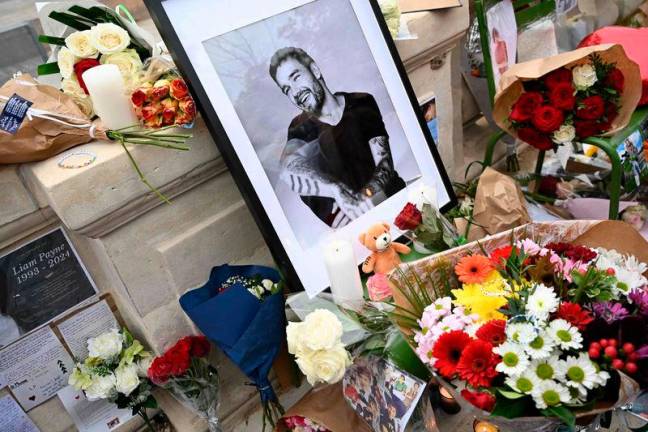 This photograph shows displayed flowers and a framed picture of late British singer Liam Payne as fans gather to pay tribute to the former member of the British pop band One Direction, at Jardin des Tuileries in Paris, on October 20, 2024. AFPPIX