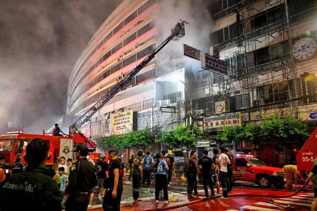 Firefighters douse fire near Yaowarat road at Chinatown in Bangkok on July 6, 2024. - AFPpix