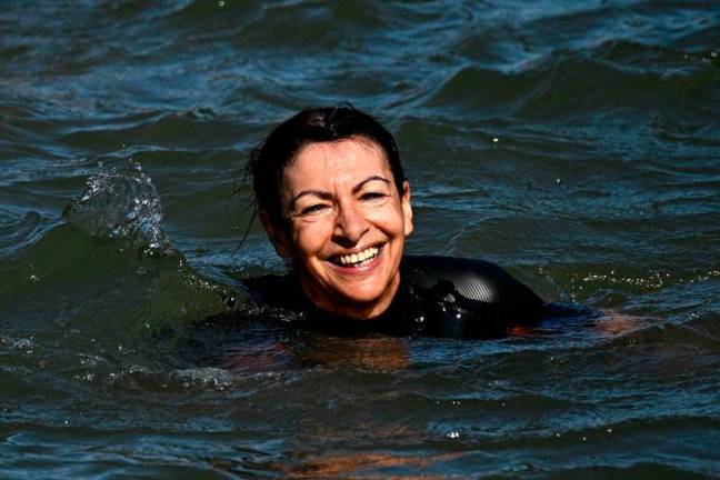 Paris Mayor Anne Hidalgo swims in the Seine, in Paris on July 17, 2024, to demonstrate that the river is clean enough to host the outdoor swimming events at the Paris Olympics later this month / AFPpix