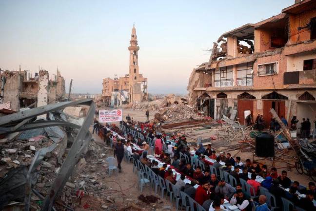 This aerial photograph shows Palestinians gathered for a communal iftar fast-breaking meal, amid the devastation in the Nuseirat refugee camp in the central Gaza Strip, during the Muslim holy fasting month of Ramadan. AFPpix