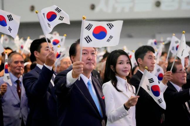 South Korean President Yoon Suk Yeol and his wife Kim Keon Hee wave the national flag during a ceremony to celebrate the 78th anniversary of the Korean Liberation Day from Japanese colonial rule in 1945, in Seoul, South Korea, Tuesday, Aug. 15, 2023. - REUTERSpix