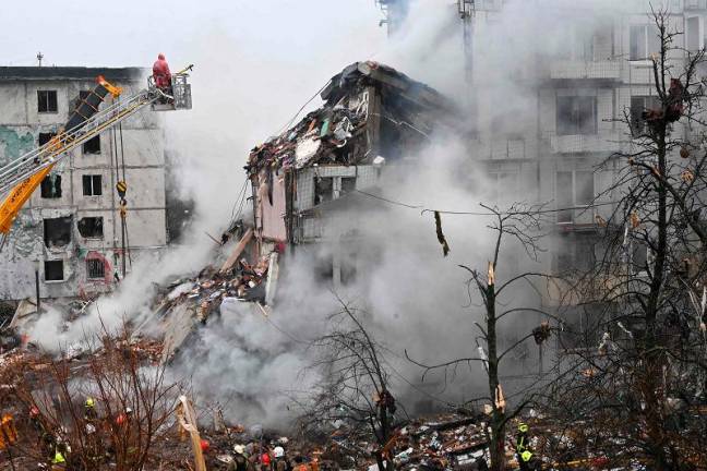 A firefighter inspects the rubble of a damaged residential building following a missile strike in Poltava on February 1, 2025, amid the Russian invasion of Ukraine. - SERGEY BOBOK / AFP