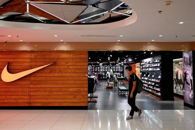 A man walks past a Nike store at a shopping mall in Hanoi July 3, 2025. Stocks struggled in Asia on July 3, 2025 as investors gave a lukewarm reception to the US-Vietnam trade deal, which sent shares of electronics and textile companies soaring — particularly those that supply Nike and Apple and operate in the Southeast Asian country. - AFP