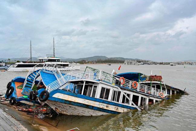 This picture shows a boat damaged after Super Typhoon Yagi hit Ha Long bay, in Quang Ninh province, on September 8, 2024. Super Typhoon Yagi uproots thousands of trees, sweeps ships and boats out to sea and rips roofs off houses in northern Vietnam, after leaving a trail of destruction in southern China and the Philippines. - Nhac NGUYEN / AFP