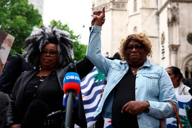 Members of the Chagossian community, Bertrice Pompe (L) and Bernadette Dugasse (R) reacts after making a statement outside the High Court in London on on May 22, 2025, after a hearing into the fate of the Chagos Islands goes against them. A judge at London's High Court on Thursday lifted a temporary block on the UK government concluding its deal to return the remote Chagos Islands to Mauritius. - HENRY NICHOLLS / AFP