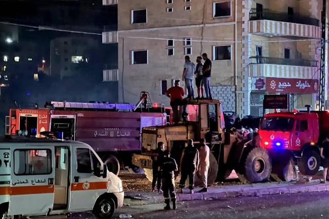 Firefighters and first responders gather at the scene of an Israeli air strike that targeted a building in the southern Lebanese town of Toul on May 22, 2025. - Mahmoud ZAYYAT / AFP