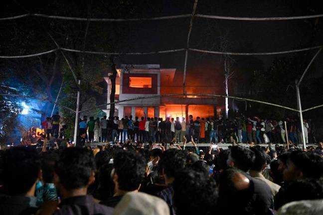 Protesters set fire to the Bangabandhu Memorial Museum, the former residence of Sheikh Mujibur Rahman father of the former Prime Minister Sheikh Hasina, as they storm the Museum, in Dhaka on February 5, 2025. Hundreds of protesters gathered at Rahman’s home after a call by Hasnat Abdullah, convener of the Anti-Discrimination Students Movement, the protest group credited with sparking the uprising against Hasina. Protesters brought excavator diggers and hammers to smash down walls at the former home of Bangladesh’s first president, with crowds cheering as fires torched the building. - Munir Uz Zaman / AFP