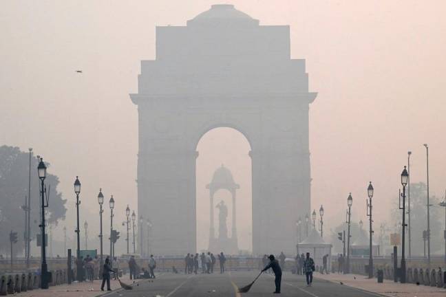 Workers clean the Kartavya Path in front of the India Gate amid heavy smoggy conditions in New Delhi on November 13, 2023. Delhi regularly ranks among the most polluted major cities on the planet, with a melange of factory and vehicle emissions exacerbated by seasonal agricultural fires. - Sajjad HUSSAIN / AFPpix