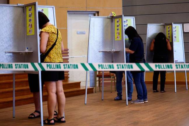 People vote at a polling station during the general election, in Singapore May 3, 2025. - REUTERS/Edgar Su