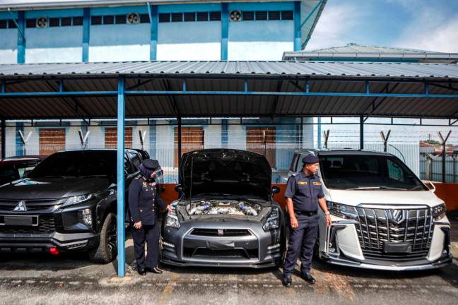 Pengarah Jabatan Pengangkutan Jalan (JPJ) Perlis, Noraini Mohd Nawi (kiri) melihat antara kenderaan mewah jenis Nissan GTR R35 dan Alphard milik ahli perniagaan yang disita ketika sidang media Ops Luxury di Ibu Pejabat JPJ Perlis- BERNAMA