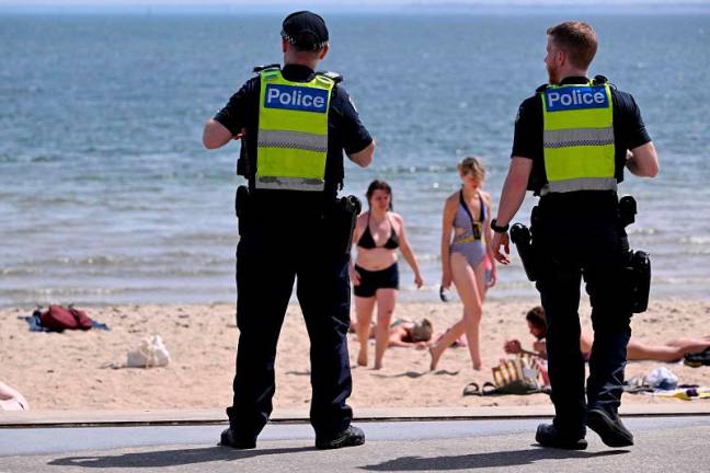 Police patrol as people cool off in heatwave conditions at Melbourne’s St Kilda Beach on November 22, 2024. - William WEST / AFPpix