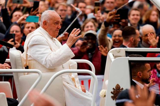 Pope Francis waves to believers as he leaves the Cercle Cite after a meeting Luxembourg’s Prime minister during a four-day apostolic journey in Luxembourg and Belgium, in Luxembourg city on September 26, 2024. - SIMON WOHLFAHRT / AFP