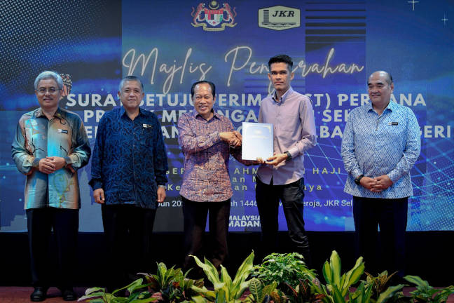 Deputy Works Minister Datuk Seri Ahmad Maslan (centre) presents the Letter of Acceptance (SST) to a recipient, who is also a contractor representative, at the SST Presentation Ceremony for the High-Density School Issue Resolution Project in various states, held at the Selangor Public Works Department today. - BERNAMApix
