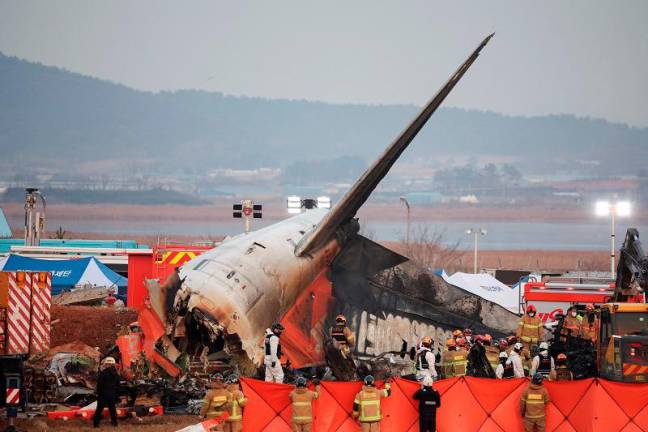 Rescue workers take part in a salvage operation at the site where an aircraft crashed after it went off the runway at Muan International Airport, in Muan, South Korea, December 29, 2024. - REUTERS/Kim Hong-Ji