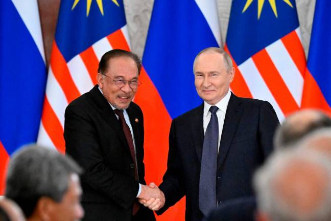 Russian President Vladimir Putin and Malaysia’s Prime Minister Anwar Ibrahim shake hands after a joint media statement following their talks at the Kremlin in Moscow on May 14, 2025. (Photo by Alexander NEMENOV / POOL / AFP)