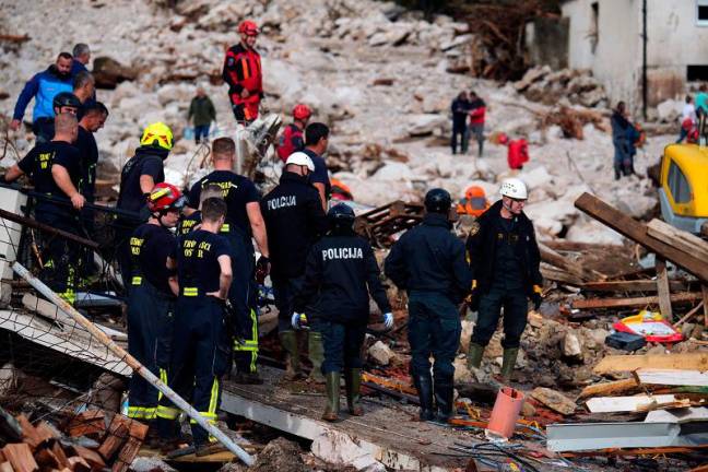 Rescuers search for survivors in flooded houses near Neretva river canyon, following heavy rains in the village of Donja Jablanica, about 50 kilometres south-west of Sarajevo on October 5, 2024. Local authorities indicate grim possibility that between 14 and 20 persons might have lost their lives after getting caught in their homes, by flood waters carrying large quantities of debris and mud. - ELVIS BARUKCIC / AFP