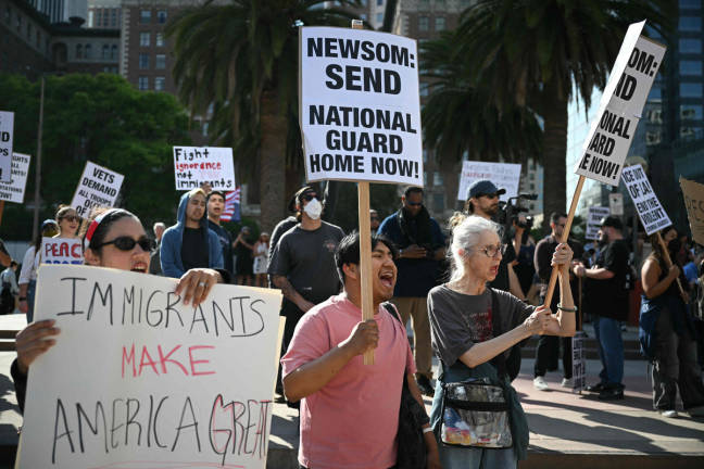 Protesters hold signs during a protest against federal immigration operations at Pershing Square in downtown Los Angeles, on June 11, 2025. - AFPpix