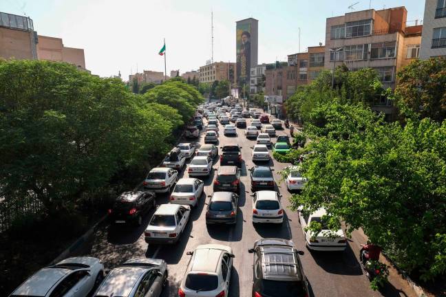Vehicles await in traffic as people get out of Tehran through an artery in the city’s west on June 15, 2025. Iranian media said an Israeli strike hit the Tehran police headquarters in the city centre on June 15, as the two foes exchanged fire for a third day. - Atta KENARE / AFP