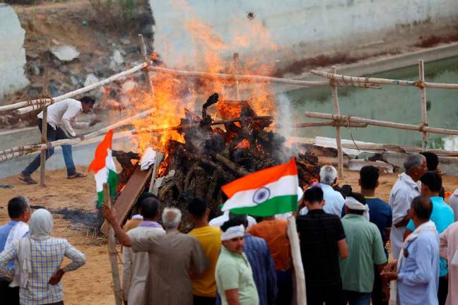 People attend the cremation of IAF (Indian Air Force) soldier Surendra Kumar who died during an attack on Udhampur, on the day of his funeral in Mahradasi village, Jhunjhunu in Rajasthan, India, May 11, 2025. REUTERS/Anushree Fadnavis