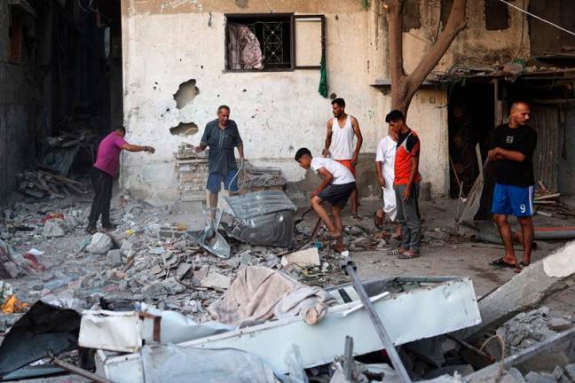 Palestinians check the area following Israeli strikes in Nuseirat in the central Gaza Strip, on September 13, 2024, amid the ongoing war in the Palestinian territory between Israel and Hamas. - Eyad BABA / AFP