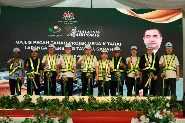 Loke (5th from left) officiating the groundbreaking of Tawau Airport upgrading work, with government agency officials and Azam Jaya management.