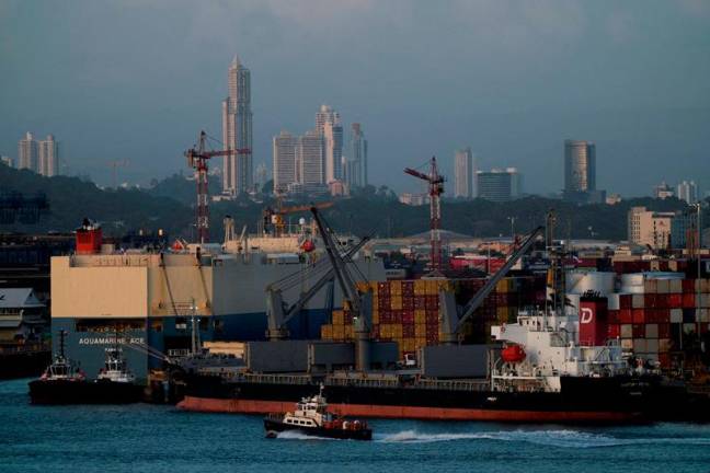 A tugboat sails past the Panama-flagged bulk carrier Century Royal and containers, in Panama City, Panama January 24, 2025. - REUTERS/Enea Lebrun/File Photo