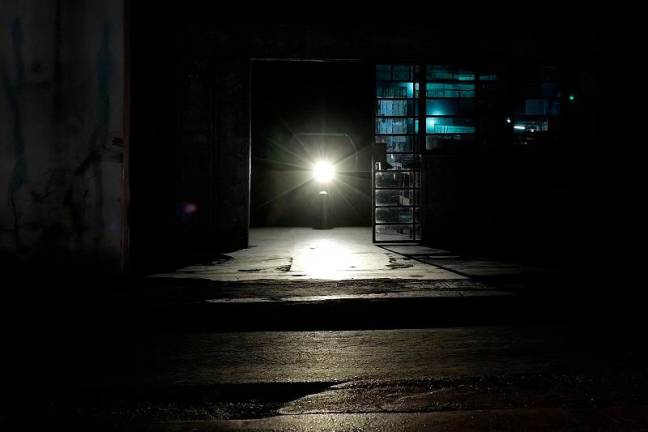 A street is lit by motorcycle lights during a nationwide blackout caused by a grid failure in Havana on December 4, 2024. Cash-strapped Cuba on Wednesday was struggling to revive its power grid, after fixing a failure at the country’s largest power plant, which had caused yet another nationwide blackout. - ADALBERTO ROQUE / AFP