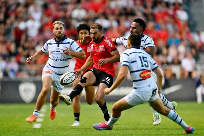 Toulon’s French full-back Melvyn Jaminet kicks the ball past Castres’ French wing Theo Chabouni (R) during the French Top14 playoff rugby union match between Rugby Club Toulonnais (Toulon) and Castres Olympique at the Stade Mayol in Toulon, south-eastern France, on June 14, 2025. - Christophe SIMON / AFP