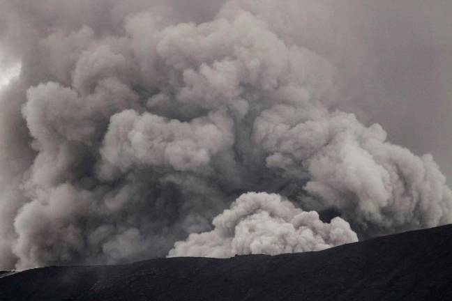 Mount Marapi spews colomns of volcanic ash during an eruption as seen from Sungai Pua in Agam, West Sumatra, on December 6, 2023. Indonesian rescuers were searching on December 6 for the final hiker who went missing after a volcano eruption that left 22 other people dead, but hopes were fading three days after the disaster. - ADI PRIMA / AFPpix