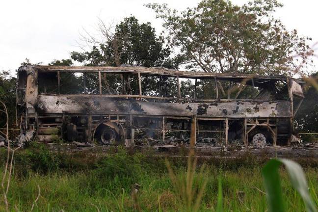 A burned bus is pictured after colliding with a trailer during its journey from Cancun to Tabasco, where people died in the accident, according to local media, near Escarcega, Campeche state in southern Mexico February 8, 2025. - REUTERS/Luis Manuel Lopez