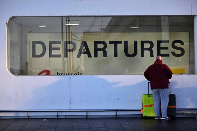 A passenger stands at the departures terminal during a strike at the Brussels Airport, in Zaventem on January 13, 2025, as part of a national day of actions called by trade unions to protest against the government plans to reform the pensions.- ERIC LALMAND / BELGA / AFP