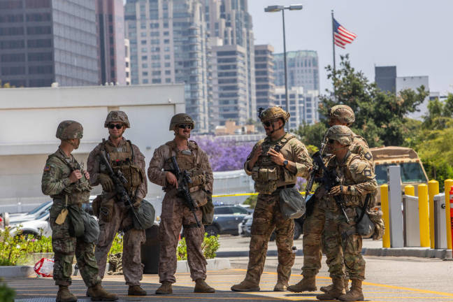 Two U.S. Marines (2nd, 3rd left) stand with California National Guard service members in the entrance of the Wilshire Federal Building on June 13, 2025, in Los Angeles, California. - AFPpix