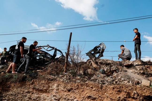Palestinians inspect a vehicle damaged in an Israeli airstrike, in Zeita, near Tulkarm, in the Israeli-occupied West Bank, August 3, 2024. - REUTERS/Raneen Sawafta