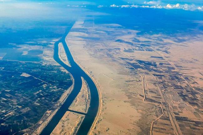 This picture taken on March 23, 2024 shows an aerial view of the new extension to the Suez Canal which was inaugurated in 2015 at al-Ferdan, north of Ismailia in northeastern Egypt. - Khaled DESOUKI / AFP