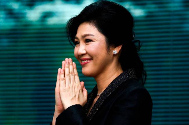 Ousted former Thai prime minister Yingluck Shinawatra greets supporters as she arrives at the Supreme Court in Bangkok, Thailand, August 1, 2017. - REUTERS/Athit Perawongmetha/File Photo