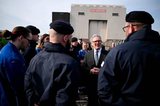 Britain's Prime Minister Keir Starmer speaks to Royal Navy Submariners of the HMS Agamemnon nuclear submarine and to BAE system apprentices outside of the BAE system factory, in Barrow-in-Furness, Britain, March 20, 2025. - OLI SCARFF/Pool via REUTERS