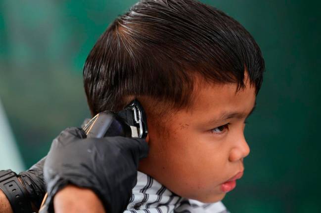 Pengunjung cilik tidak melepaskan peluang mendapatkan perkhidmatan gunting rambut secara percuma di reruai Jabatan Sukarelawan Malaysia (RELA) pada Program MADANI Rakyat (PMR) 2025 Negeri Sembilan di Dataran Nilai hari ini. - Bernama