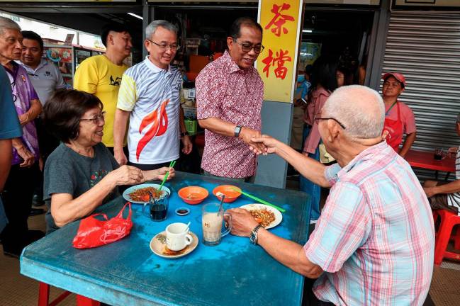 Menteri Pertahanan, Datuk Seri Mohamed Khaled Nordin (dua, kanan) menyantuni penduduk setempat pada Majlis Ramah Mesra Bersama Masyarakat Cina Kota Tinggi di Medan Selera Muafakat hari ini. - Bernama