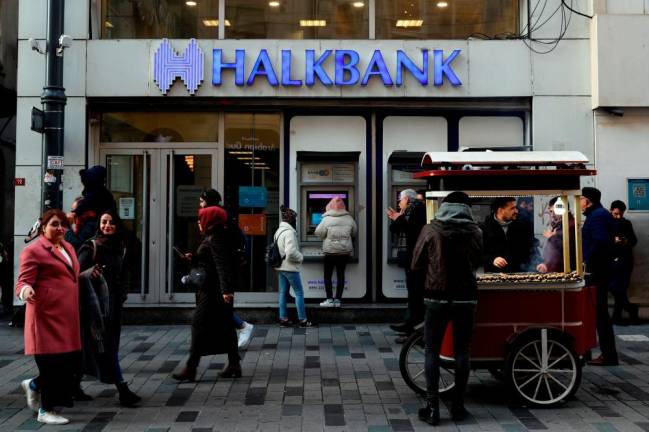 FILE PHOTO: People walk past a branch of Halkbank in central Istanbul, Turkey, January 22, 2020. -REUTERSpix